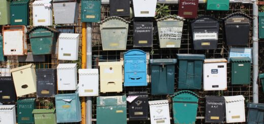 A bunch of mail boxes over a metal fence